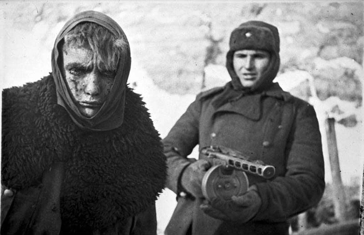 Советский солдат конвоирует пленного обмороженного немца из Шестой армии Паулюса