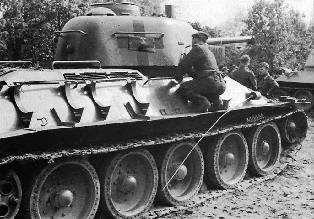 Немцы ремонтируют трофейные танки Т-34 и рисуют на них свои кресты